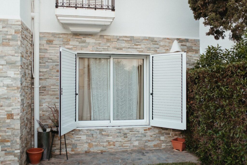 Fachada de piedra y ventanas con contraventanas